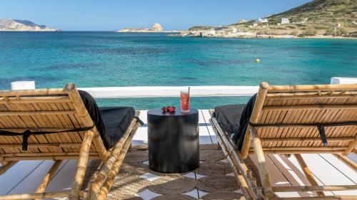 two chairs and a table on a deck with the ocean at Captain Zeppos in Pollonia