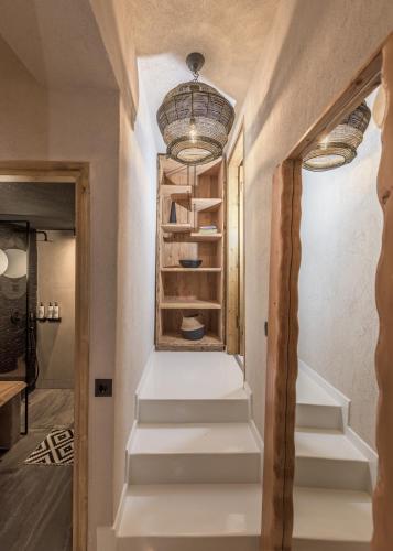 a hallway with white stairs and a chandelier at Captain Zeppos in Pollonia