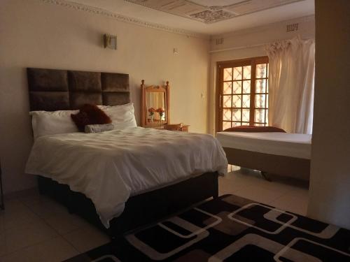 - une chambre avec un grand lit et une fenêtre dans l'établissement DEN VIEW GUESTHOUSE, à Francistown