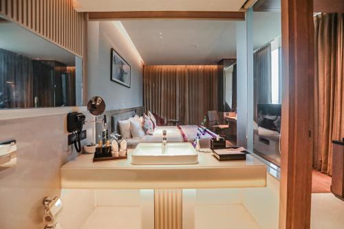 a bathroom with a sink and a living room at Regenta Place Verka Amritsar in Amritsar