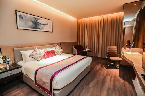 a hotel room with a bed and a desk at Regenta Place Verka Amritsar in Amritsar