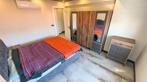 Dormitorio pequeño con cama y espejo en PALM BEACH APARTMENT en Kusadasi