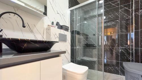a bathroom with a sink and a glass shower at PALM BEACH APARTMENT in Kuşadası