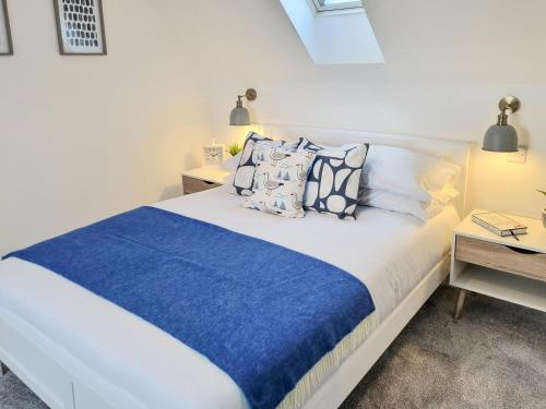 a bedroom with a large bed with blue sheets and pillows at Keyland Cottage in Johnshaven