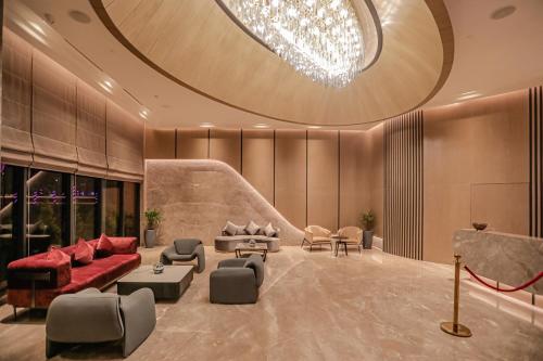 a living room with a red couch and chairs at Regenta Place Verka Amritsar in Amritsar