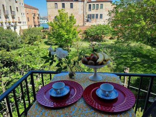 a table with plates and cups and a bowl of fruit at Angela di Venezia House in Venice