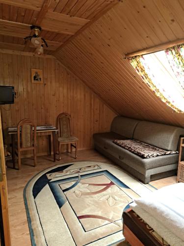 Zimmer im Dachgeschoss mit einem Bett und einem Fenster in der Unterkunft Pokoje gościnne u Joanny in Groń