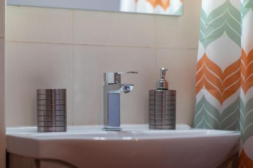 a bathroom with a sink with a faucet at Anesis Suites in Volos