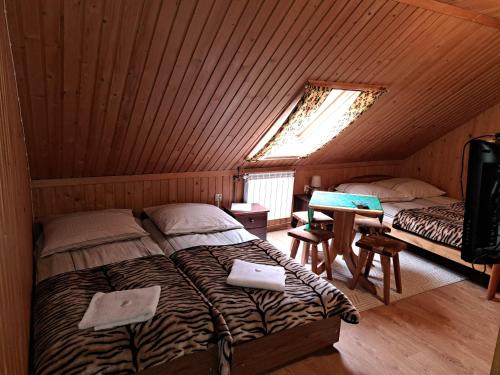 GrońにあるPokoje gościnne u Joannyの木造家屋内のベッドルーム(ベッド2台付)
