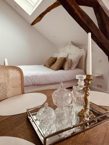 a room with a table with a candle and a bed at Studio 3 du SPA Célinie in Warcq