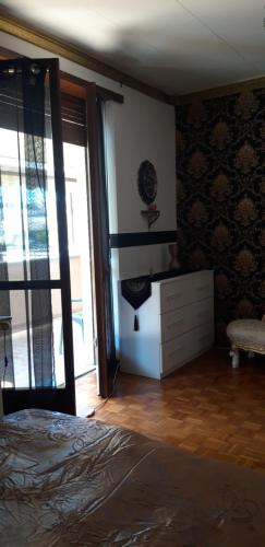 Alloggio in paese في Montà: غرفة نوم بسرير وخزانة ونافذة