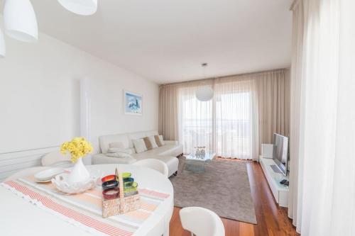 uma sala de estar branca com um sofá e uma mesa em Apartment Sunset, Zadar - Kožino em Kožino