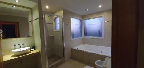 a bathroom with a tub and a sink and a shower at Alto San Andres in San Andres de las Sierras