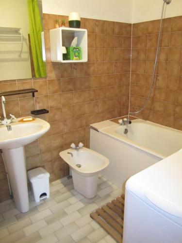 une salle de bain avec un lavabo, des toilettes et une baignoire dans l'établissement 5097 Tennis Village 1603, au Cap d'Agde
