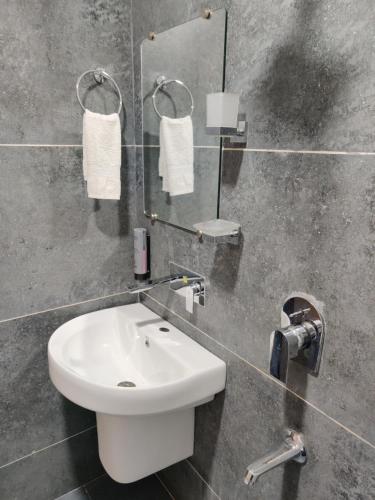 a bathroom with a white sink and a mirror at Hotel Tamanna 2 Minute Walk from Golden Temple in Amritsar