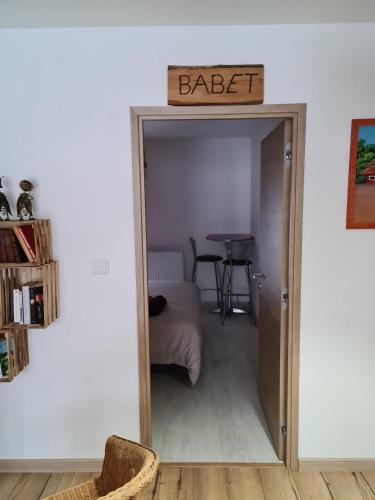 a door into a bedroom with a bed and a table at Chez perlette in Merle-Leignec