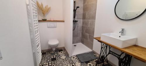 a bathroom with a sink and a toilet at Chez perlette 