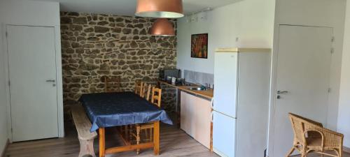 una cocina con una mesa pequeña y una cocina con una pared de ladrillo en Chez perlette, 