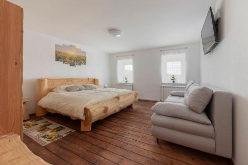 a bedroom with a bed and a couch at Počitniška Hiša Pr Martinovih in Postojna