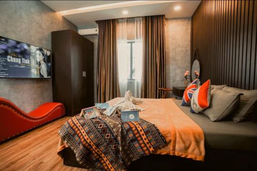 a bedroom with a bed with an orange blanket at MIS HOSTEL Cần Thơ in Can Tho