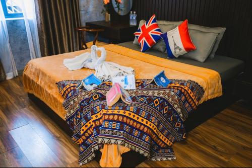 a bedroom with a bed with a blanket on it at MIS HOSTEL Cần Thơ in Can Tho