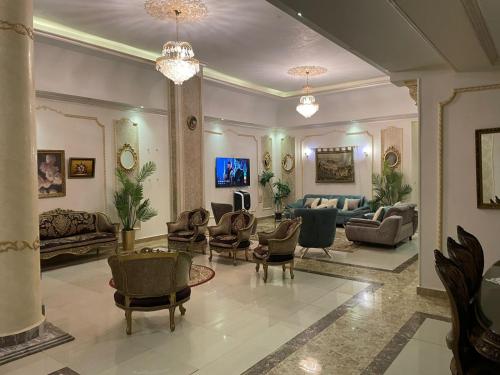 a living room with couches and chairs at Trio Villa with coverable private pool in compound near Mall of Egypt in Sheikh Zayed