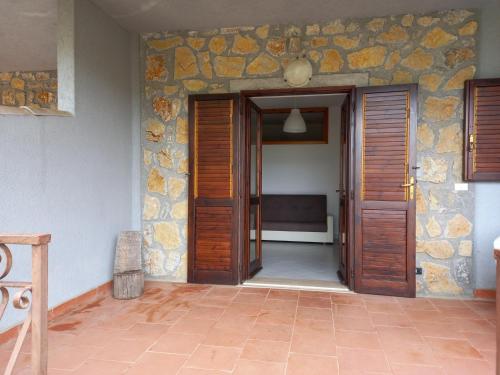 una camera con due porte in legno e un muro in pietra di Villetta Elaion a Scario