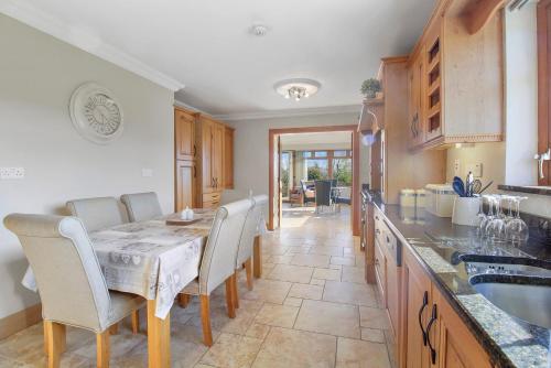 a kitchen with a table and chairs and a counter at Rose Cottage in Muff