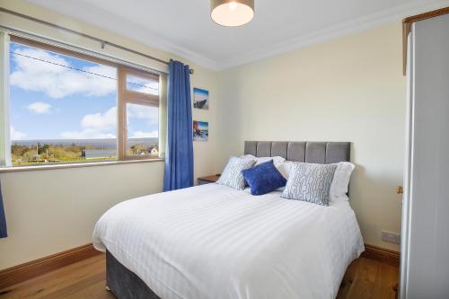 a bedroom with a large bed with a large window at Rose Cottage in Muff