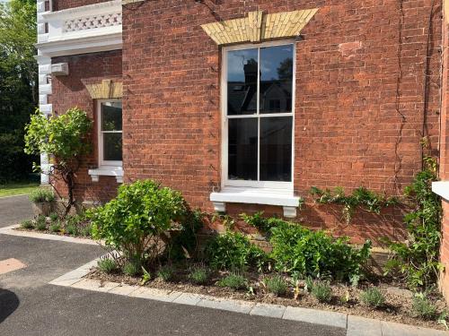 a brick building with a window on the side of it at Townhouse - free parking, garden & games room in Exeter