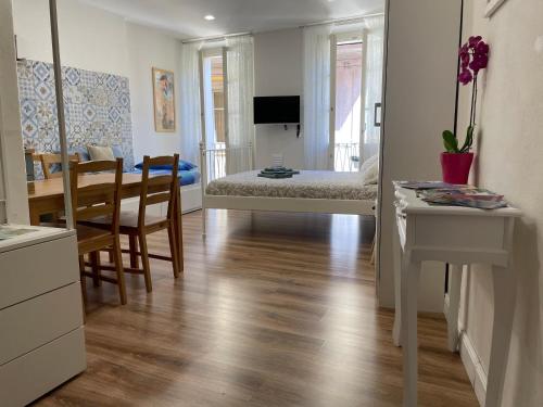 a bedroom with a bed and a table and chairs at Holiday Studio in Centro Storico Intra in Intra
