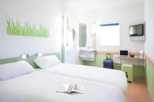 una camera d'albergo con un letto e un libro sopra di ibis budget Poitiers Nord Futuroscope a Chasseneuil-du-Poitou