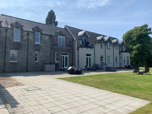 a large brick building with a courtyard in front of it at Lomond View in Luss
