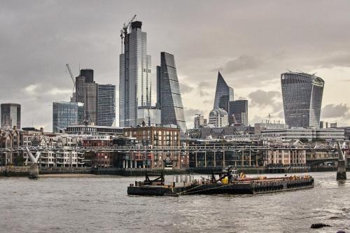 zwei Lastkähne auf dem Wasser vor einer Stadt in der Unterkunft Montcalm East, Autograph Collection in London