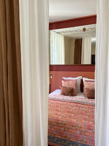 una camera con un letto e un grande specchio di Studio terracotta a La Ciotat