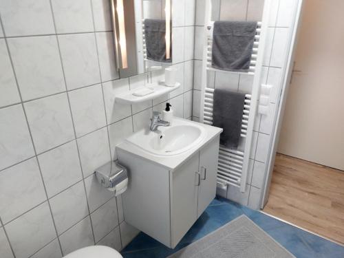 een witte badkamer met een wastafel en een toilet bij Ferienwohnung Grabner in Waging am See