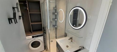 een kleine badkamer met een wastafel en een spiegel bij Studio Village Naturiste Lollipop in Cap d'Agde