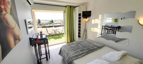 um quarto com uma cama e uma varanda com vista em Studio Village Naturiste Lollipop em Cap d'Agde