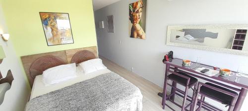 een kleine kamer met een bed en een tafel bij Studio Village Naturiste Lollipop in Cap d'Agde