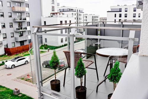 a balcony with a table and chairs and a view of a city at Lavender Hill Apartment in Gdańsk