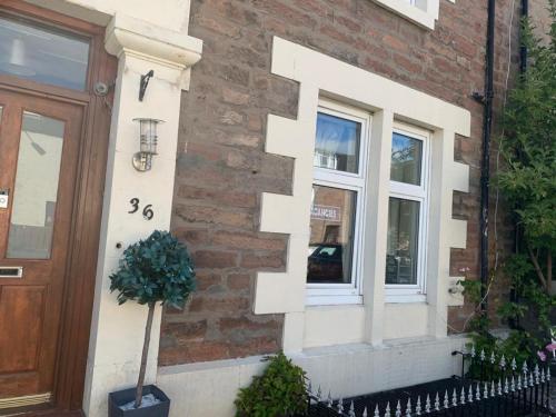 a brick house with a door and a window at Budget Rooms in Inverness