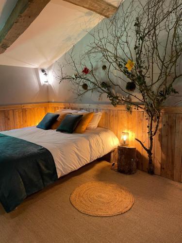 a bedroom with a bed with a tree in it at Domaine des Granges Neuves in Confrançon