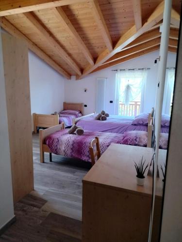 een slaapkamer met 2 bedden en een houten plafond bij Agritur Lavanda in Nave San Rocco