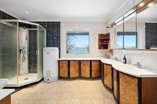 baño grande con 2 lavabos y ducha en Hus med egen strandlinje, en Tromsø
