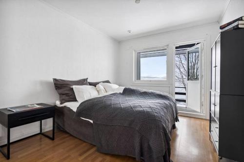 1 dormitorio con cama y ventana en Hus med egen strandlinje, en Tromsø