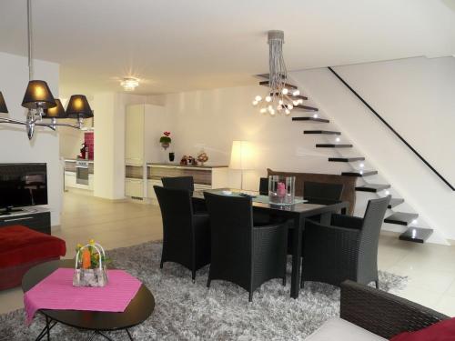 a living room with a table and chairs and a staircase at ABC Apartment in Blankenberge
