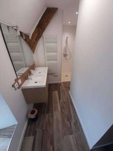 une salle de bain avec deux lavabos et deux fenêtres dans l'établissement Les gîtes du val, à Mandeville-en-Bessin