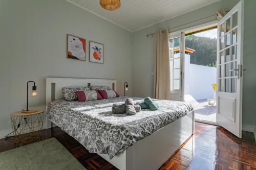 a bedroom with a bed and a sliding glass door at Casa da Praia dos Moinhos in Ribeira Grande