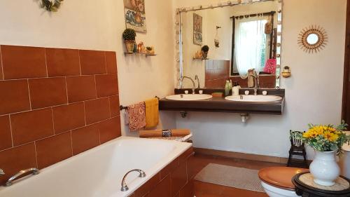 une salle de bain avec deux lavabos et une baignoire dans l'établissement Villa CAMBOUNET, Maison cosy à quelques kilomètres des plages, à Béziers