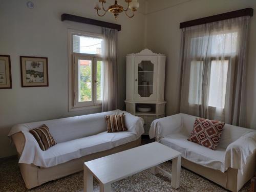 a living room with two white couches and a table at house in the village near the sea in Maleme